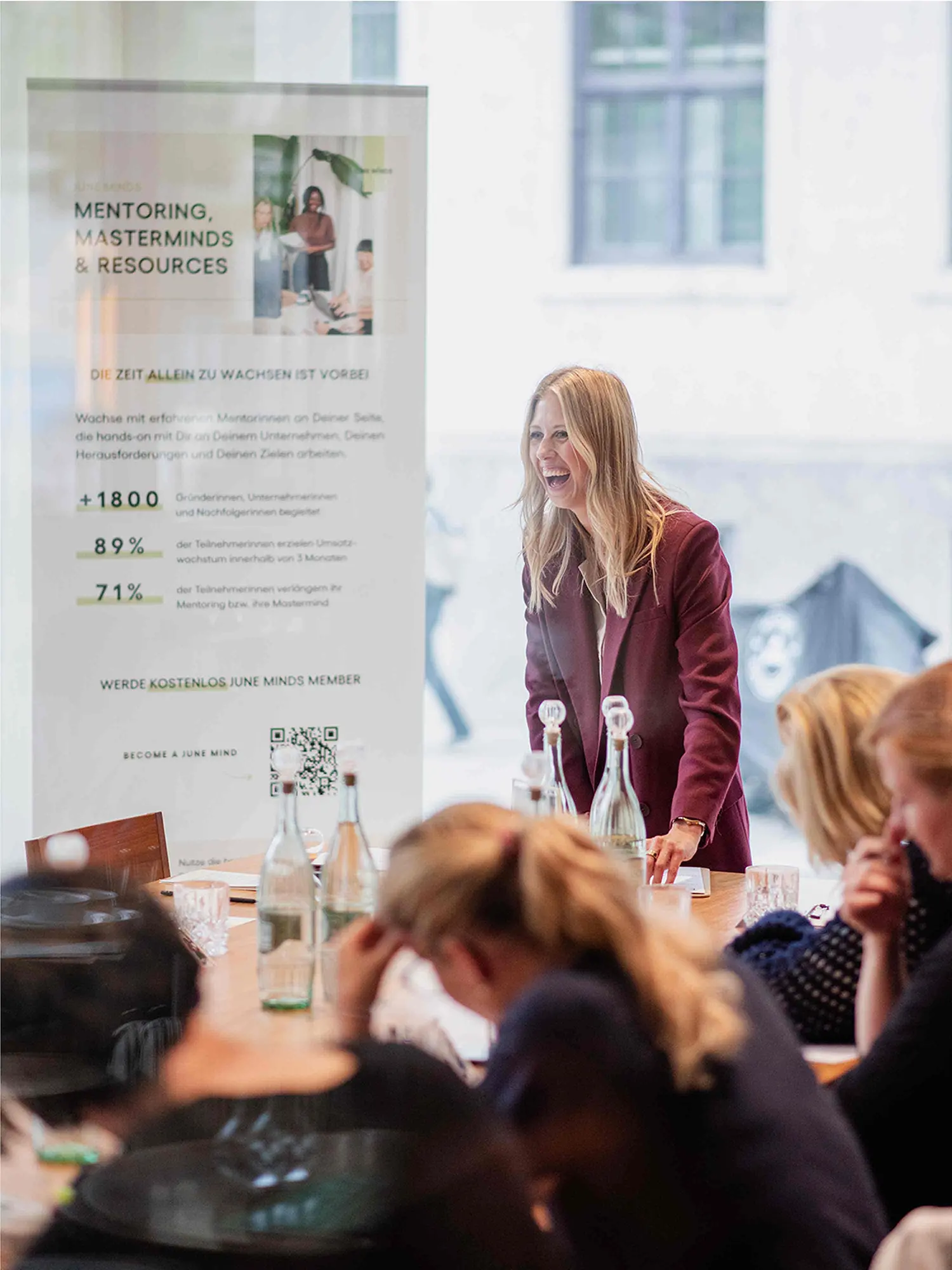 Magdalena spricht mit Teilnehmenden während eines Business-Workshops in einem Meetingraum