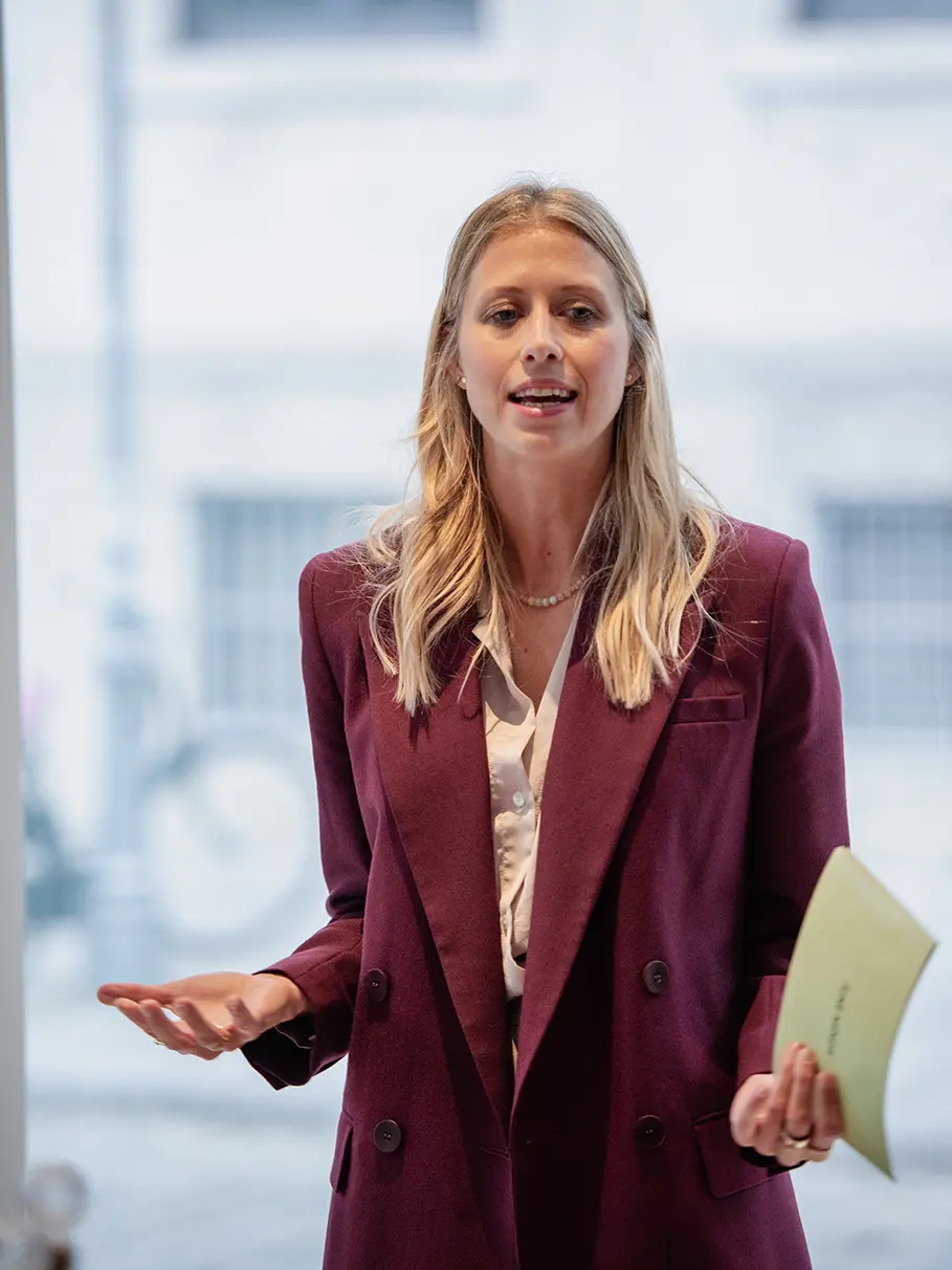 Magdalena präsentiert mit Unterlagen in der Hand während eines Business-Vortrags