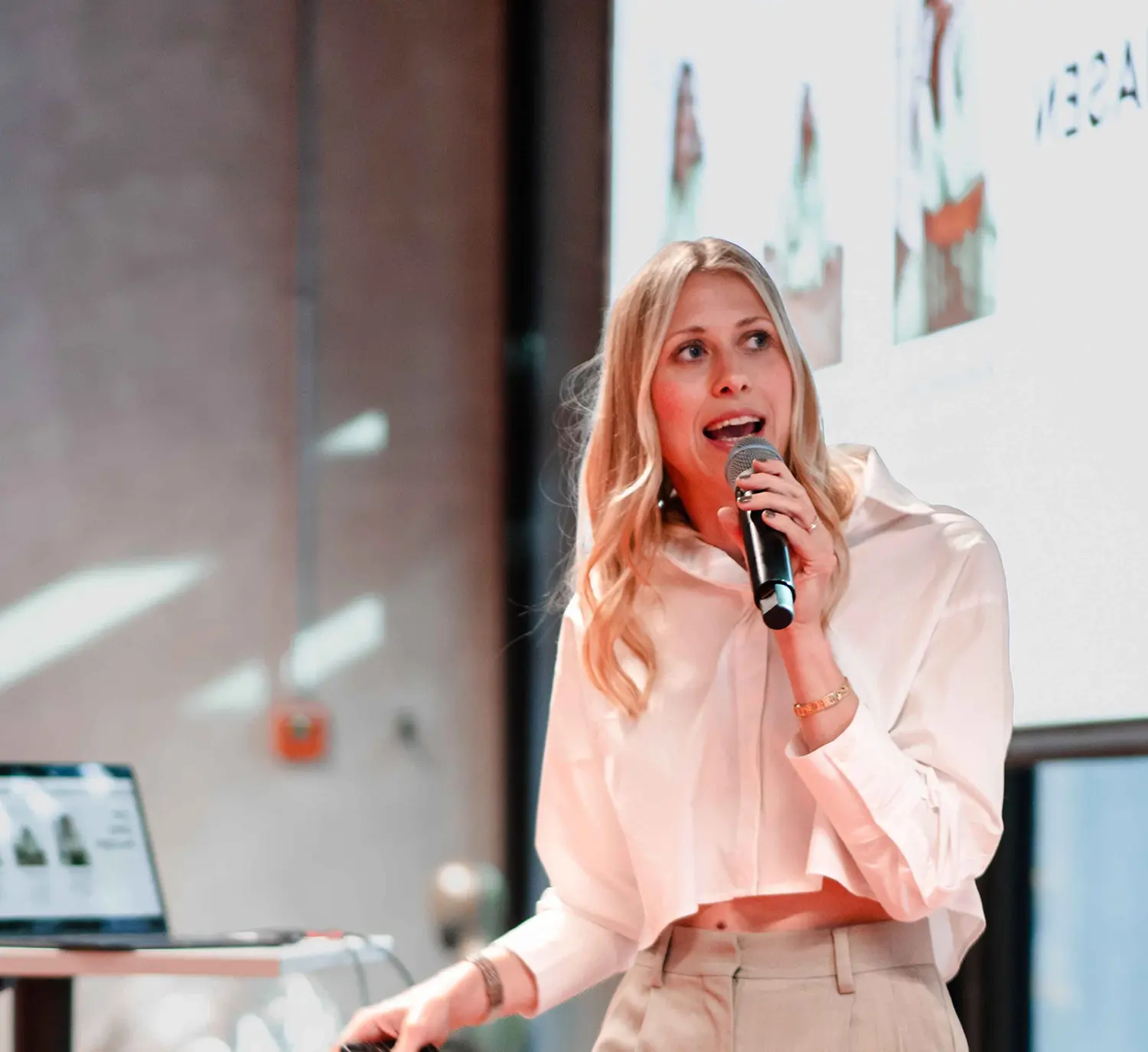 Magdalena hält als Speakerin einen Vortrag mit Mikrofon bei einer Business-Präsentation